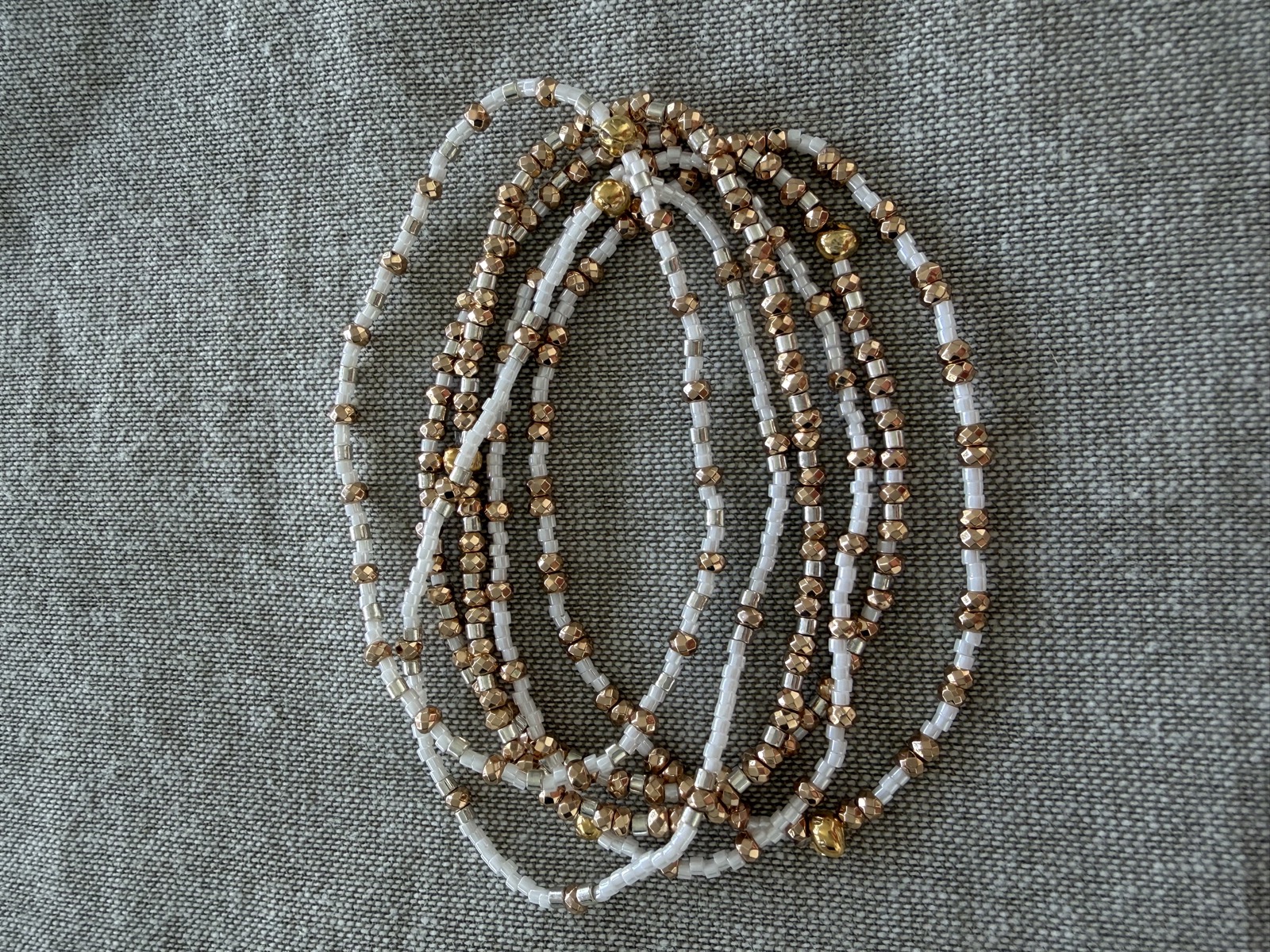 Close-up of gold and cream beaded bracelets