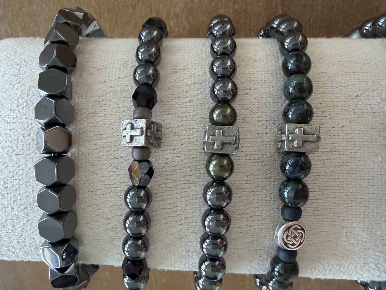 A row of dark stretch bracelets with cross detail beads