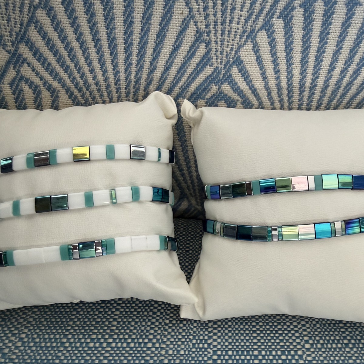 Mermaid Tila tile bracelets stacked on display pillows